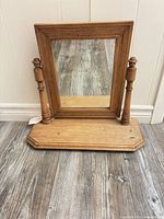 Front view of mirror on base showing frame, supports and base