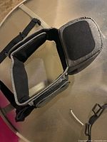Top view showing open interior compartment and side pocket of grey hip seat carrier