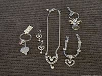 Entire lot laid out: necklace, bracelet, earrings pair, two keychains