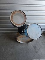 Black Slingerland rack tom above blue Ludwig Vistalite tom mounted on black bass drum