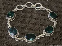 Full view of bracelet arranged in circle showing all five stones and clasp