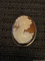 Front view showing carved shell cameo and sterling frame