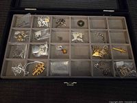 Full view of display case showing all compartments with bagged jewelry pieces