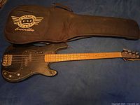 Full view of Epiphone bass guitar alongside soft gig bag
