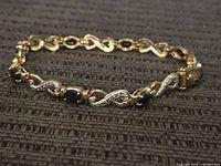 Full view of bracelet lying flat in oval shape showing overall design and clasp