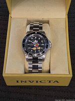 Watch in Invicta box, bracelet around pillow