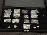 Display case with multiple bagged jewelry items visible in compartments