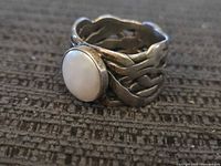 Front view showing oval white cabochon and woven band