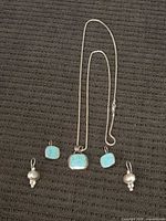 Necklace, two turquoise pendants, pair silver earrings displayed