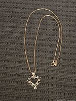 Necklace full view laid flat on dark background