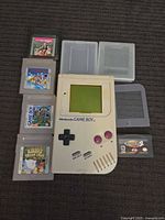 Group shot of Game Boy console, six cartridges and two cases
