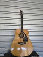 Full front view of Yamaha dreadnought guitar hanging vertically