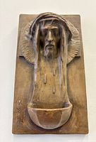 Front view of terracotta holy water font showing full relief and basin