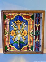 Front view of stained glass window showing full design and wood frame