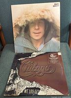 Front covers of both LP albums displayed on chair