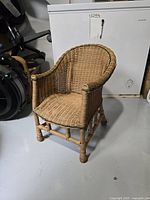 Front angled view of the child-size wicker chair showing full structure and condition