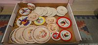 overview of box showing assorted tin toy plates, two heart cups, porcelain plates stack