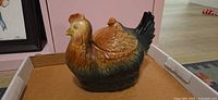 Front view of glazed ceramic hen cookie jar with lid in place