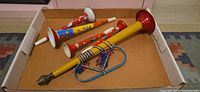 Four tin horns in box