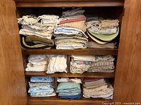 Cabinet shelves filled with folded assorted linens