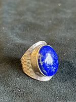 Front view of hammered sterling silver ring with oval lapis lazuli cabochon