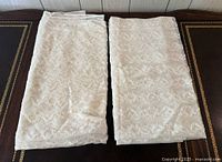 Two folded curtain panels side-by-side showing overall fabric