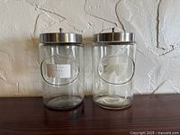 Front view of both glass jars on wooden surface