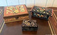 Three decorative trinket boxes on table