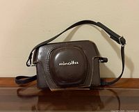 Front of brown Minolta leather case with strap