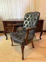 Front angle view showing entire chair with desk backdrop