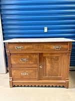 Front view of wood washstand with marble top