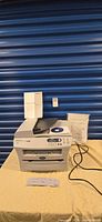 Full view of Brother DCP-7020 printer with manuals and power cord
