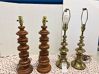 Group shot of two wood lamps and two brass lamps