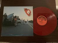 Front of album sleeve and red vinyl disc displayed