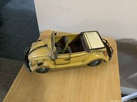 Angled top view of yellow metal VW Beetle convertible
