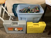 Blue tote filled with K’NEX pieces, grey and yellow K’NEX cases in front
