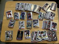 Wide view of assorted Panini NHL stickers spread on table, showing mix of regular and foil variants.