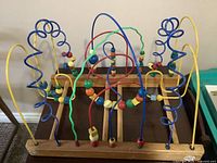 Front view of wooden bead maze showing full structure and bead tracks