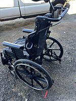 Rear side view showing frame, wheels, push handles, anti-tip bars