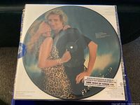 Front view of sealed picture disc showing Rod Stewart with woman