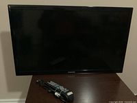 Front view of Samsung TV with remote on table