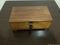 Closed wooden box showing dovetail corners and latch