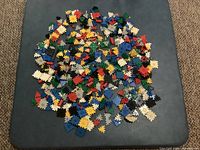 Pile of small interlocking Zaks pieces in multiple colors on table