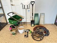 Full lot showing spreader, fertilizer, shovel, planters, hoses, solar lights