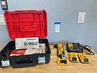 Overall shot showing drill, two batteries, charger and toolbox