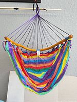 Multicolor rainbow hammock chair with wooden spreader bar and hanging ropes