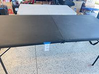 Both folding tables set up; black in front, white behind