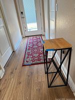 Runner rug with accent table in hallway