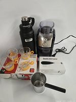 Group shot showing all items including grinder, thermos, boxed foamer, pitcher and cups