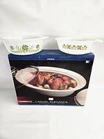 Boxed CorningWare baker with two loose green floral dishes on top